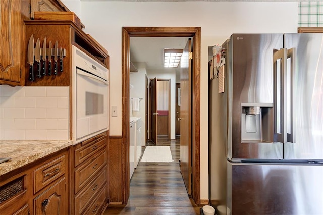 5708 NW 87th St, Oklahoma City, OK 73132 - kitchen with stainless steel fridge, oven, dark wood-type flooring, brown cabinetry, and decorative backsplash