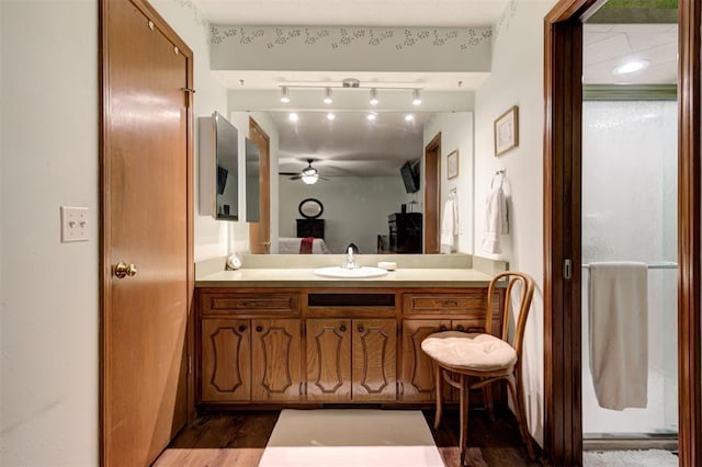 5708 NW 87th St, Oklahoma City, OK 73132 - bathroom with connected bathroom, a ceiling fan, vanity, rail lighting, and wood finished floors