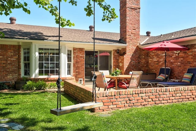 5708 NW 87th St, Oklahoma City, OK 73132 - back of property with brick siding, a chimney, a patio area, a lawn, and roof with shingles