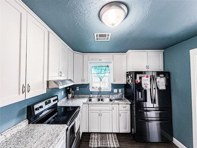 206 N Donald Ave, El Reno, OK 73036 - kitchen with stainless steel appliances, a sink, under cabinet range hood, white cabinetry, and a textured ceiling