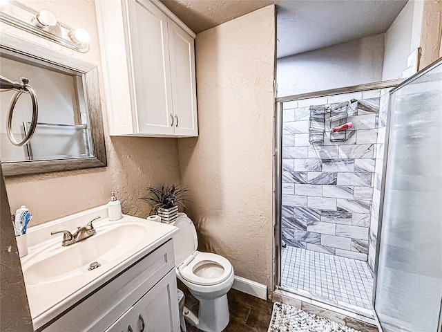 206 N Donald Ave, El Reno, OK 73036 - bathroom featuring a textured wall, a shower stall, toilet, vanity, and baseboards