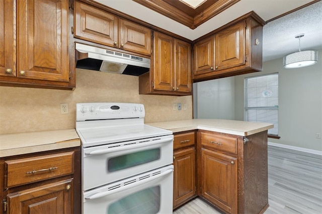 1104 Cedar Hill Pl, Oklahoma City, OK 73110 - kitchen featuring double oven range, under cabinet range hood, brown cabinetry, and a peninsula