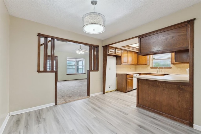 1104 Cedar Hill Pl, Oklahoma City, OK 73110 - kitchen with light wood finished floors, light countertops, a textured ceiling, baseboards, and brown cabinetry