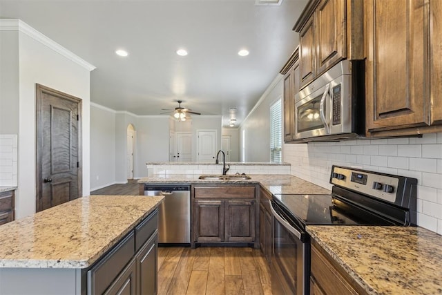 8345 NW 137th St, Oklahoma City, OK 73142 - kitchen featuring appliances with stainless steel finishes, a sink, a ceiling fan, light wood-type flooring, and ornamental molding