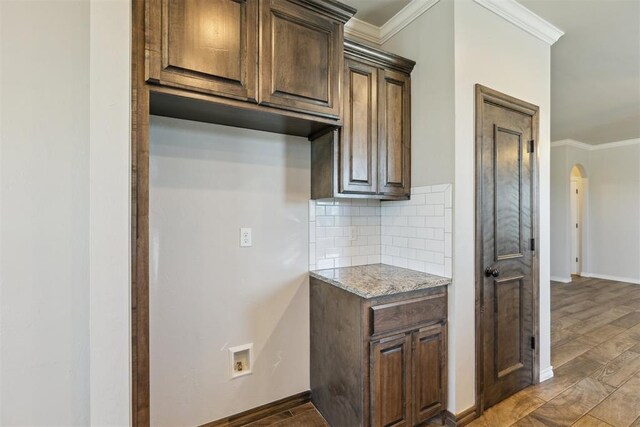 8345 NW 137th St, Oklahoma City, OK 73142 - kitchen featuring arched walkways, baseboards, tasteful backsplash, ornamental molding, and dark brown cabinets