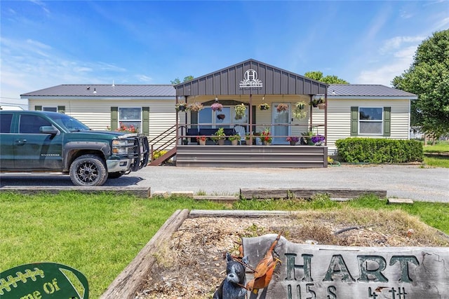 rear view of property with metal roof and a porch