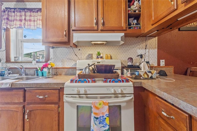 kitchen featuring range hood, white range oven, a sink, brown cabinetry, and light countertops