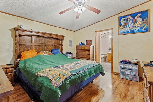 bedroom featuring vaulted ceiling, crown molding, a textured ceiling, wood finished floors, and a ceiling fan