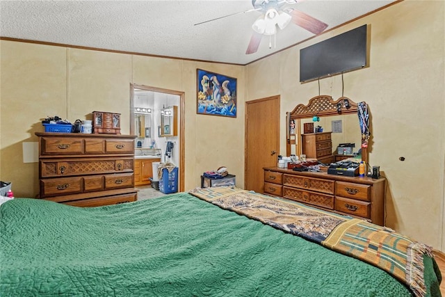 bedroom with ornamental molding, a textured ceiling, connected bathroom, and ceiling fan