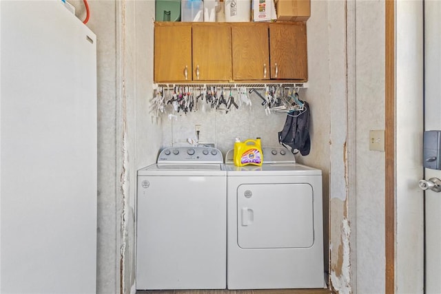 laundry room featuring separate washer and dryer and cabinet space