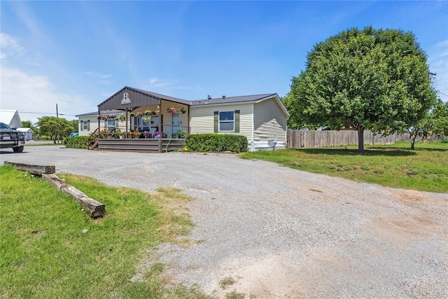 manufactured / mobile home featuring driveway and covered porch