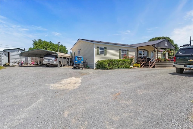 manufactured / mobile home with a detached carport and asphalt driveway