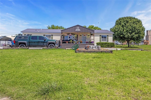view of front of property featuring a front yard, a detached carport, and metal roof