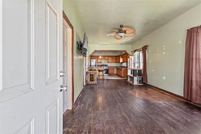 305 N Reimer, Corn, OK 73024 - unfurnished living room with ceiling fan, dark wood-style flooring, and baseboards