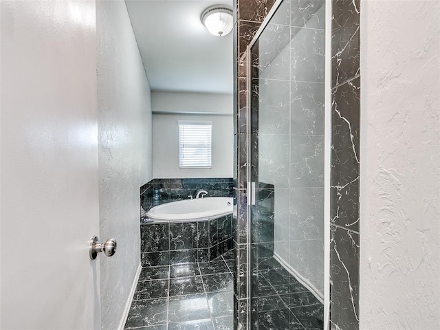 3605 Country Clb, Moore, OK 73160 - bathroom featuring marble look tile flooring, a garden tub, and a textured wall