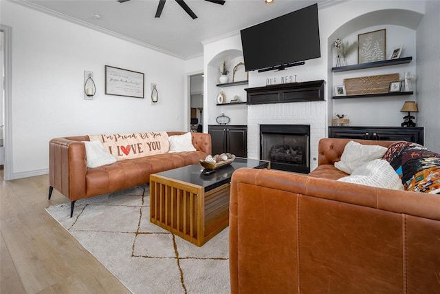 271 Taylam Rd, Goldsby, OK 73093 - living area with ornamental molding, a ceiling fan, light wood-style flooring, and a fireplace