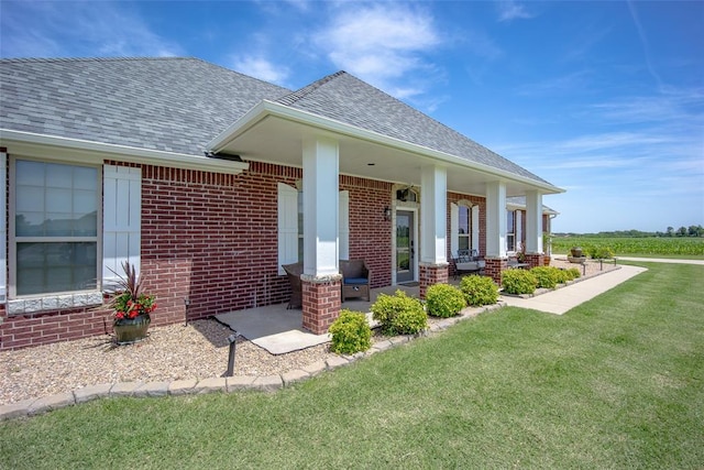 271 Taylam Rd, Goldsby, OK 73093 - view of front facade with brick siding, a shingled roof, a front lawn, and covered porch