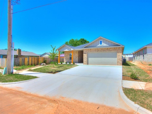 single story home featuring concrete driveway, a garage, brick siding, and board and batten siding
