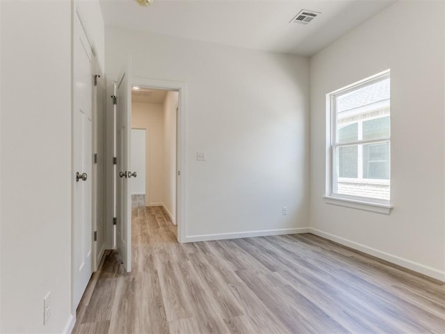 empty room with light wood-type flooring and baseboards