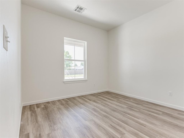 spare room featuring light wood finished floors and baseboards