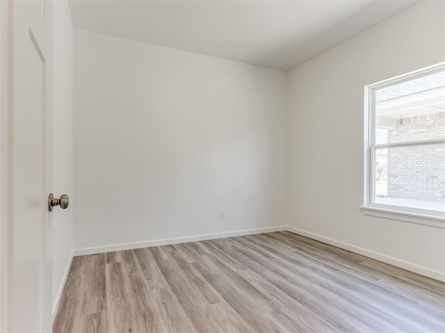 spare room with light wood-style flooring and baseboards