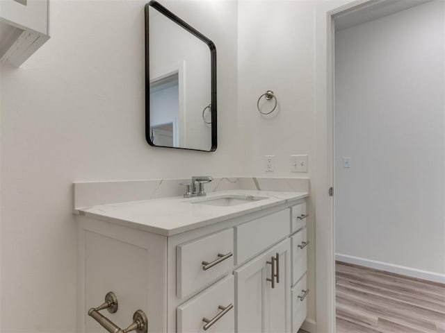 bathroom featuring wood finished floors, vanity, and baseboards