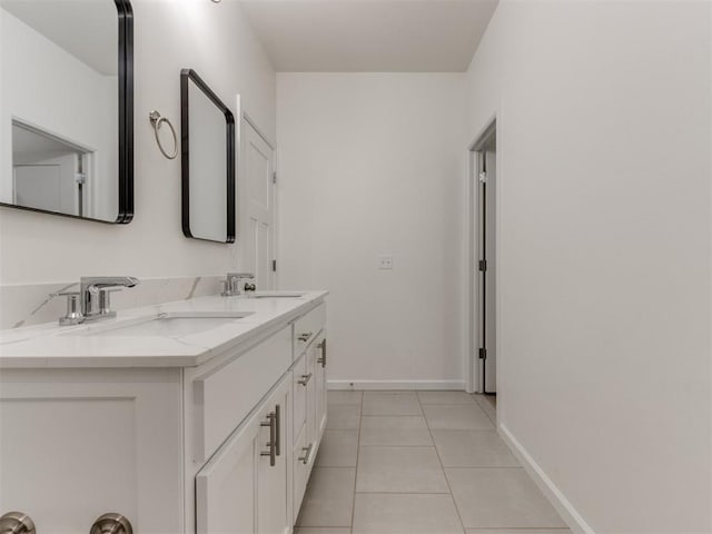 full bath featuring tile patterned flooring, baseboards, and double vanity