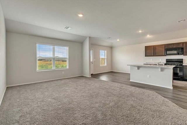 11700 NW 95th St, Yukon, OK 73099 - kitchen featuring black appliances, open floor plan, a center island with sink, baseboards, and recessed lighting