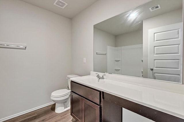 11700 NW 95th St, Yukon, OK 73099 - bathroom featuring wood finished floors, toilet, vanity, baseboards, and a shower
