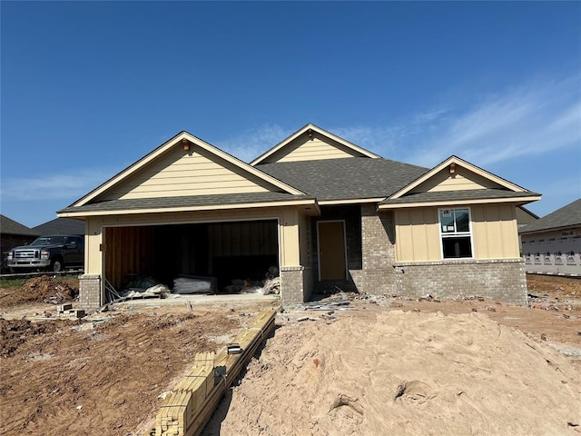 4302 Eloise Dr, Shawnee, OK 74804 - property under construction featuring brick siding, a garage, roof with shingles, and board and batten siding