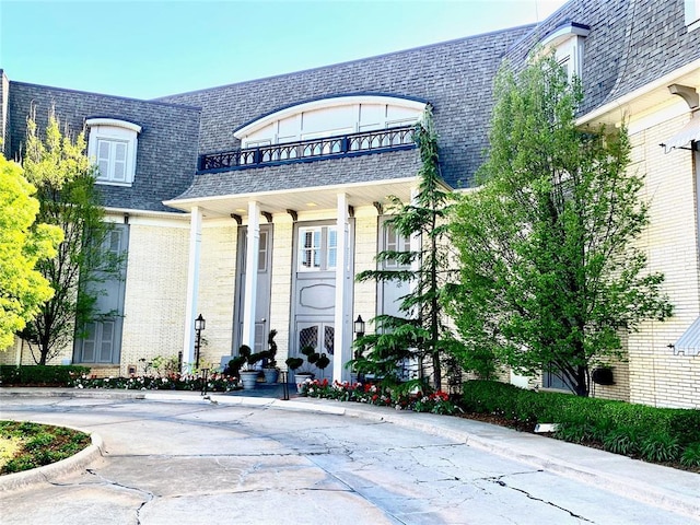 1114 Sherwood Ln Unit B-2, Nichols Hills, OK 73116 - entrance to property with brick siding, a balcony, mansard roof, and roof with shingles