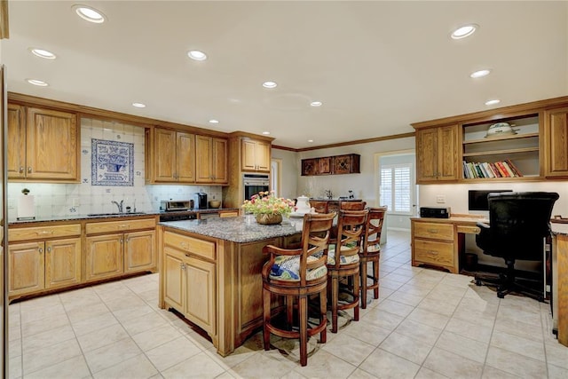 1114 Sherwood Ln Unit B-2, Nichols Hills, OK 73116 - kitchen with stainless steel oven, a kitchen island, a sink, light tile patterned floors, and a breakfast bar area