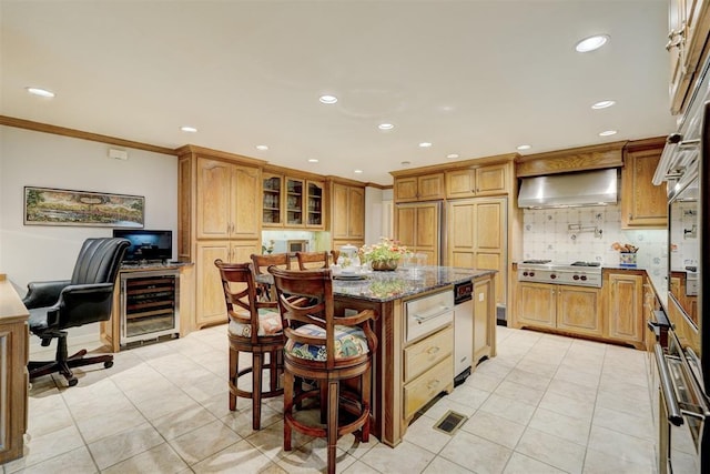 1114 Sherwood Ln Unit B-2, Nichols Hills, OK 73116 - kitchen with wall chimney exhaust hood, beverage cooler, light tile patterned floors, a center island, and stone counters