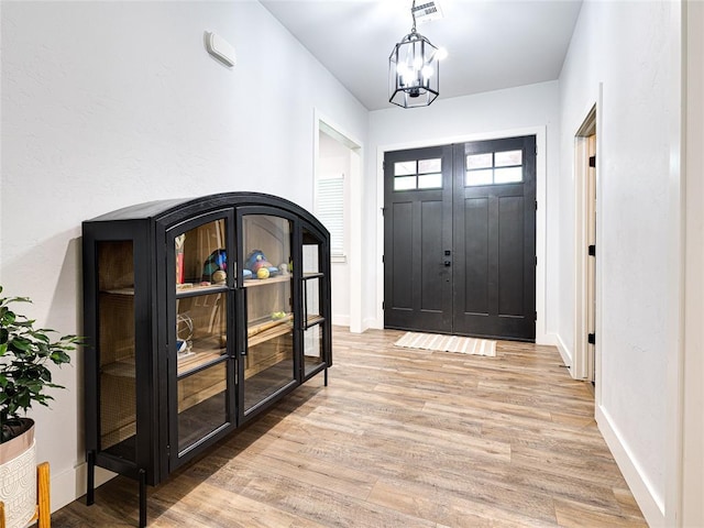 1614 S 1st Ave, Stroud, OK 74079 - entryway with light wood-type flooring, a chandelier, and baseboards