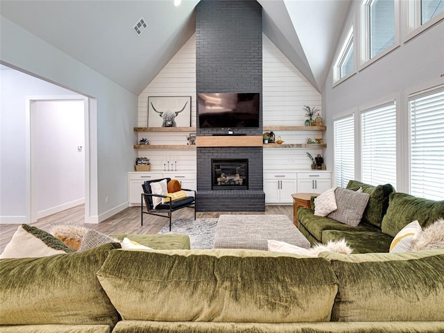 1614 S 1st Ave, Stroud, OK 74079 - living area featuring high vaulted ceiling, a brick fireplace, light wood-style floors, baseboards, and wood walls