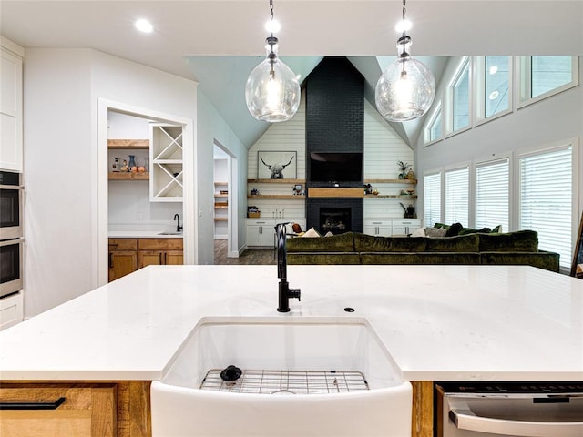 1614 S 1st Ave, Stroud, OK 74079 - kitchen with dishwasher, a sink, a brick fireplace, pendant lighting, and lofted ceiling