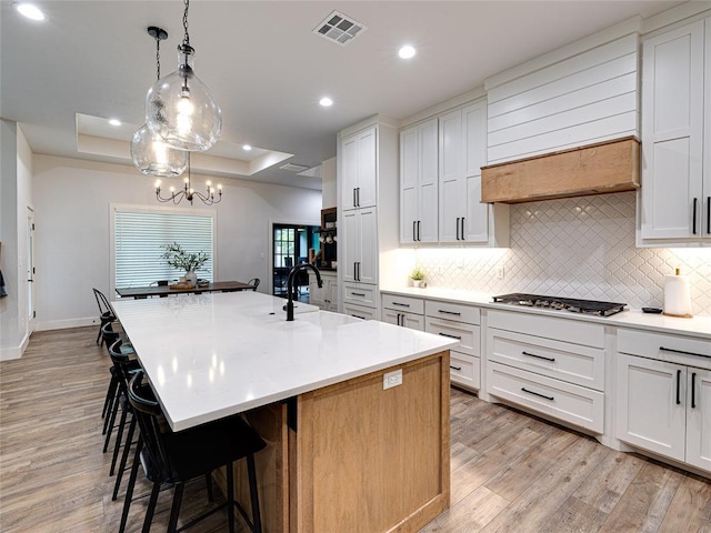 1614 S 1st Ave, Stroud, OK 74079 - kitchen featuring a sink, a tray ceiling, backsplash, light wood finished floors, and recessed lighting