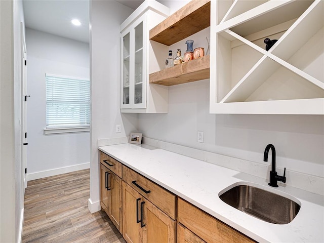1614 S 1st Ave, Stroud, OK 74079 - kitchen with a sink, open shelves, light wood finished floors, baseboards, and glass insert cabinets