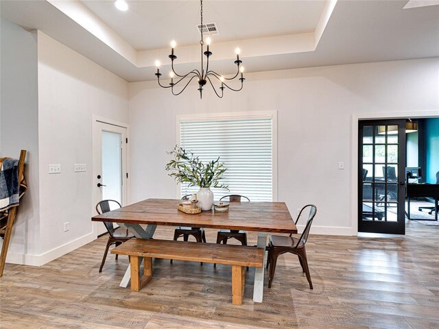 1614 S 1st Ave, Stroud, OK 74079 - dining space featuring a tray ceiling, baseboards, wood finished floors, and a chandelier