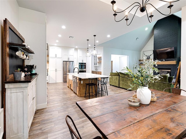 1614 S 1st Ave, Stroud, OK 74079 - dining space with recessed lighting, light wood finished floors, lofted ceiling, a chandelier, and baseboards