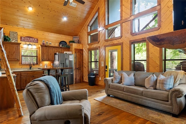 962 Red Fox Rd, Broken Bow, OK 74728 - living area with wood walls, high vaulted ceiling, light wood finished floors, and ceiling fan