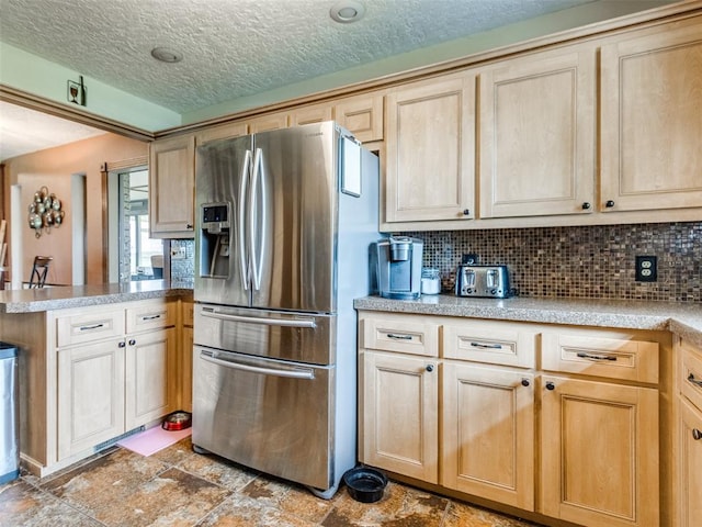 13776 E Stella Rd, Newalla, OK 74857 - kitchen featuring stainless steel fridge, a peninsula, light brown cabinetry, decorative backsplash, and stone finish floors