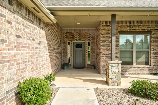 12535 Memory Ln, Edmond, OK 73025 - doorway to property featuring roof with shingles and brick siding