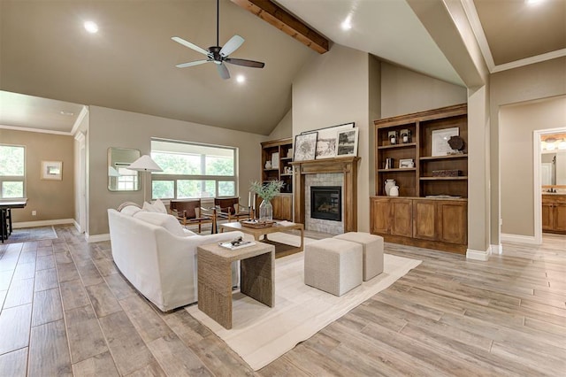 12535 Memory Ln, Edmond, OK 73025 - living room featuring ceiling fan, beam ceiling, baseboards, light wood-type flooring, and a glass covered fireplace