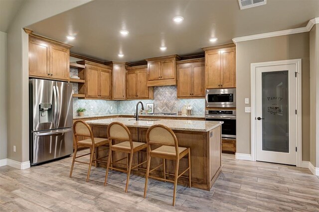 12535 Memory Ln, Edmond, OK 73025 - kitchen with appliances with stainless steel finishes, open shelves, ornamental molding, baseboards, and light wood-type flooring