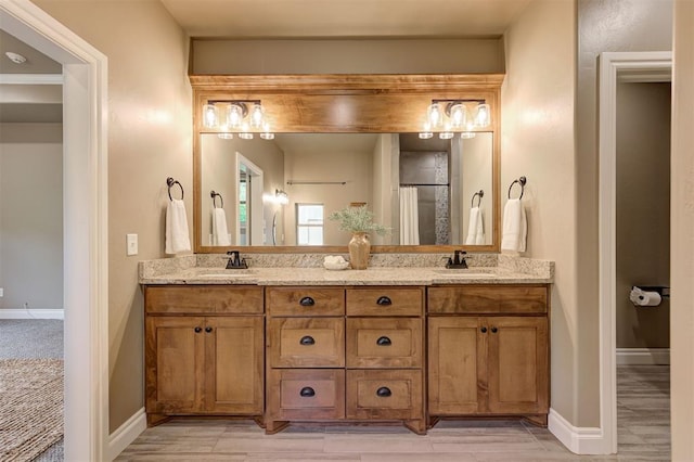12535 Memory Ln, Edmond, OK 73025 - full bath with baseboards, double vanity, and wood finished floors