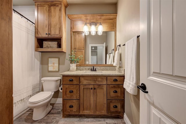 12535 Memory Ln, Edmond, OK 73025 - full bath with toilet, vanity, wood finished floors, and baseboards