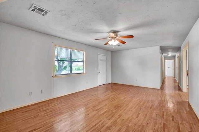 15001 Garr Pl, Oklahoma City, OK 73165 - unfurnished room featuring light wood-style floors, a ceiling fan, baseboards, and a textured ceiling