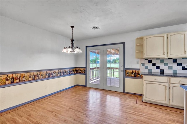 15001 Garr Pl, Oklahoma City, OK 73165 - kitchen featuring light wood-style flooring, dark countertops, tasteful backsplash, a chandelier, and decorative light fixtures