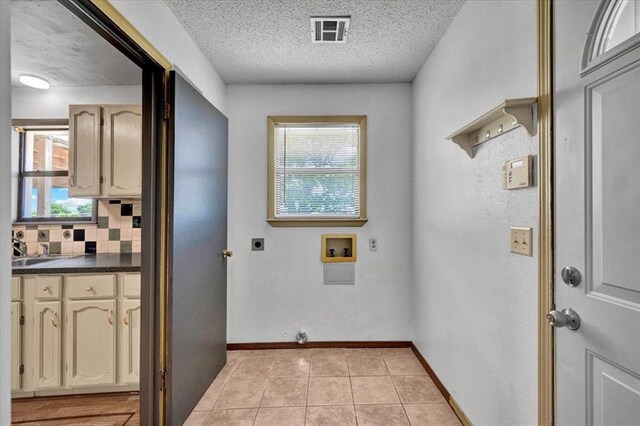15001 Garr Pl, Oklahoma City, OK 73165 - laundry area with hookup for an electric dryer, hookup for a washing machine, a textured ceiling, baseboards, and light tile patterned floors
